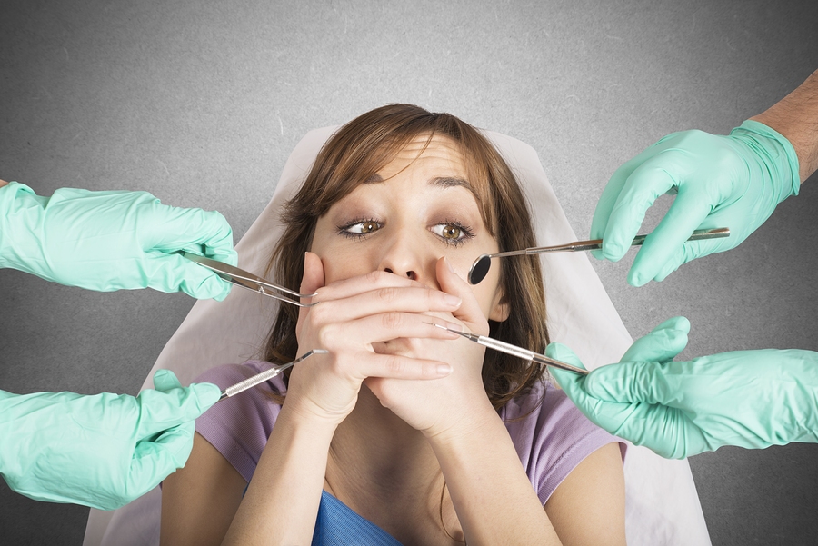 woman in dental chair has dental anxiety, shields mouth from dental tools. Auburn, CA sedation dentistry